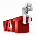 Postać siedząca na napisie VAT