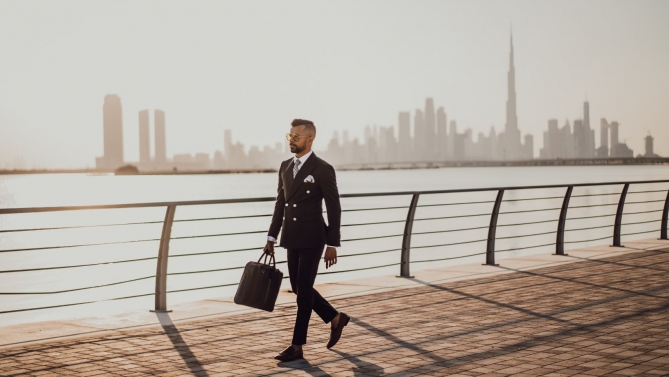 Zdjecie przedsiębiorcy spacerującego po deptaku na tle panoramy miasta